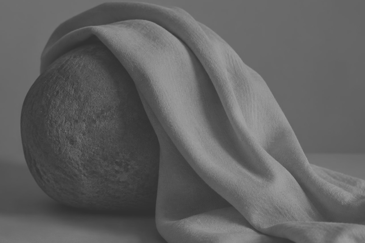 Zwart-witfoto van licht doek dat over een steen valt